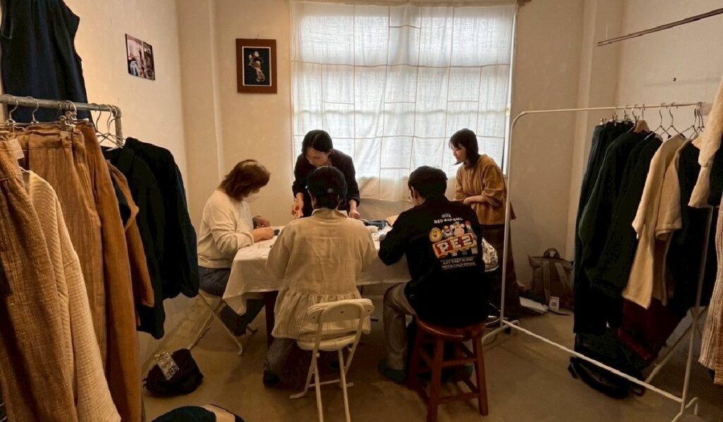 机を囲んで熱心に刺繍をする参加者
