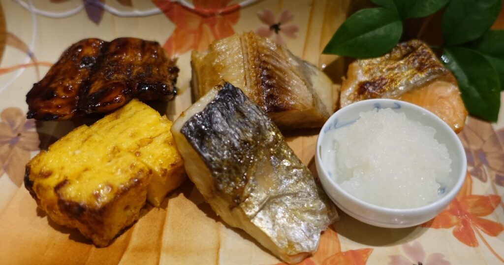 左上からサワラの照り焼き、ホッケ、サケの塩焼き、卵焼き、アジの塩焼き、大根おろしの土佐酢和え