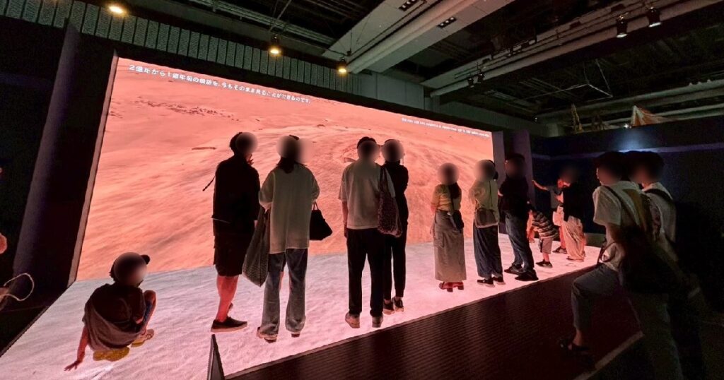 足下と目の前の大画面に映る火星の風景