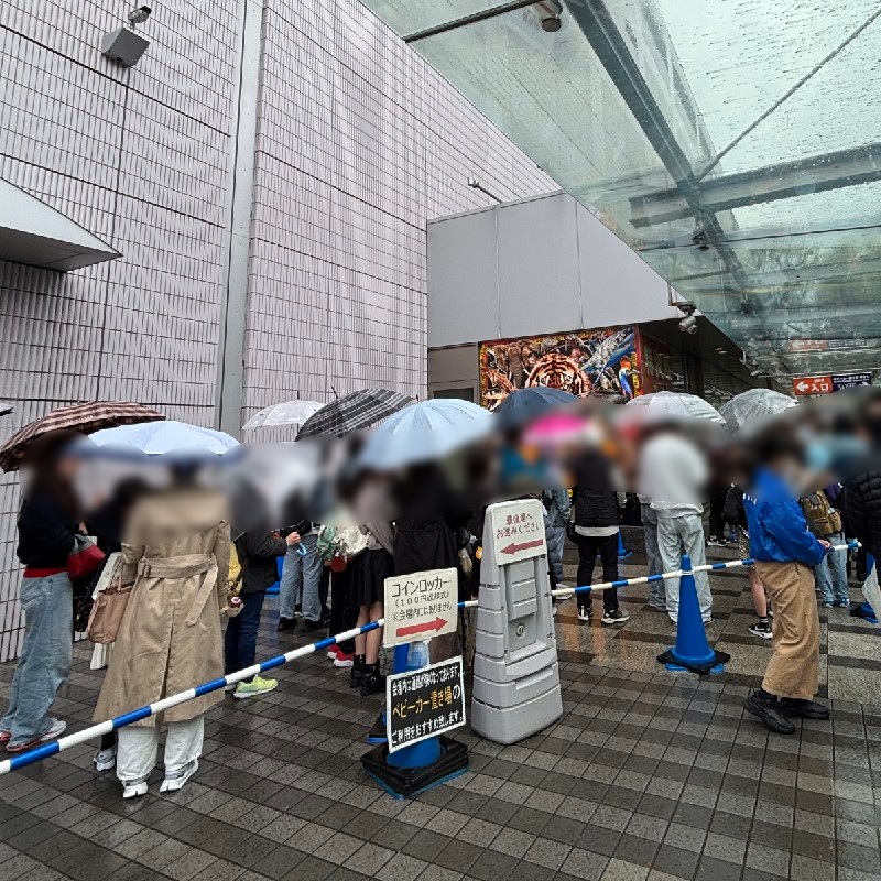 12時30分頃の会場外　雨模様でも傘差しで並ぶ様子