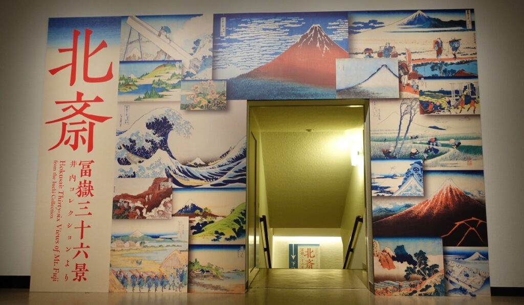 会場の地下３階への階段を囲う『冨嶽三十六景展』の看板