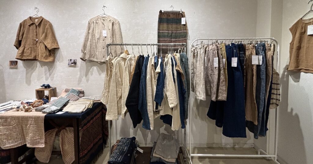 草木染のやわらかで深みのある色合いの衣服が並ぶ